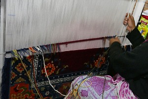 Un momento della lavorazione al telaio di un tappeto: in un locale malsano per infiltrazioni d'acqua e umidità diffusa, un gruppo di donne Newari appartenenti alla casta dei "Sudra" (servi) lavora ai telai la lana ed altri filati per oltre 10 ore al giorno: tradizionalmente il "mestiere" si tramanda di generazione in generazione e le tecniche sono le stesse da centinaia di anni. Villaggio di Khokana, Nepal 2018.