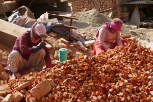 Due donne Newari appartenenti alla casta dei "Sudra" spaccano pietre e mattoni nel bel mezzo della piazza principale del villaggio di Bungamati per la ricostruzione dei Templi e delle abitazioni distrutti dal terribile terremoto de4l 2'015, Nepal 2018.