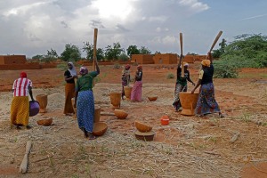 Donne Haoussa schiacciano il sorgo nei mortai di legno intagliato, Villaggio Mouja, Niger 2019