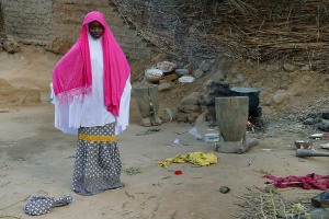 Giovane donna Haoussa cucina con il fuoco, villaggio Mouja, NIger 2019