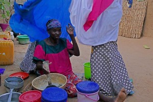 Mentre la mamma prepara il pranzo, la figlia le pone il velo sulle spalle, etnia Haoussa, villaggio Mouja, Niger 2019