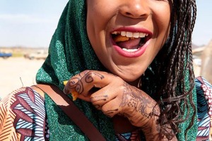 Ragazza Haoussa mostra divertita i tatuaggi temporanei realizzati con l'henné, Festival dell'Air, Iferouane, Deserto del Ténéré, Regione dell'Air, Niger 2020