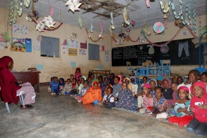 Scuola elementare nel Villaggio di Timia, i bambini seguono con attenzione la lezione dell'insegnante di etnia Haoussa, distratti solo per un'attimo dalla mia presenza, Regione dell'Air, Niger 2020