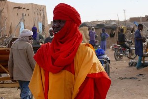 Un commerciante Tuareg attende i clienti accanto al recinto che contiene le sue capre, Mercato degli animali di Agadez, Niger 2020